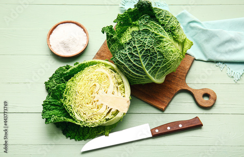 Board fresh savoy cabbage on color wooden background photo
