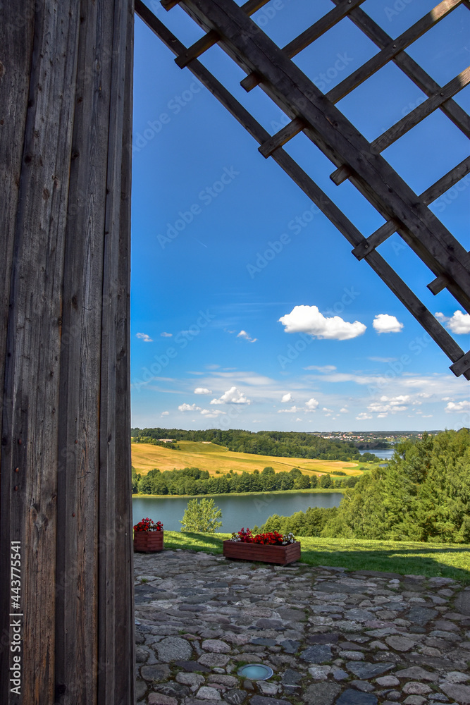 Wooden windmill wing, beautiful lake landscape in the background - obrazy, fototapety, plakaty 