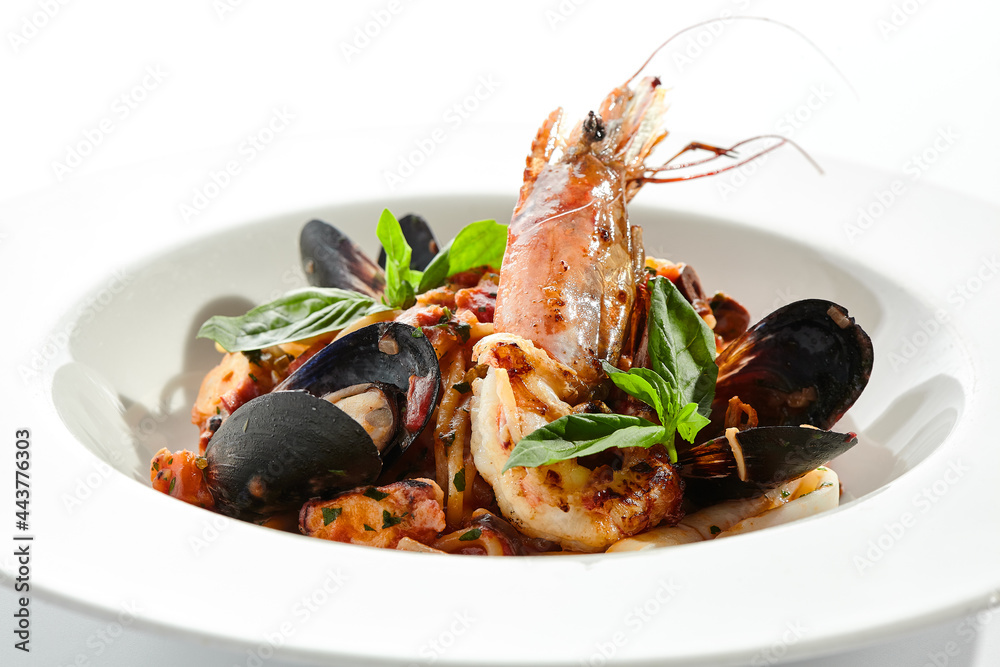Seafood spaghetti pasta - spaghetti plate with seafood mix. Pasta dish with shrimp, mussel and octopus. Restaurant gourmet seafood and pasta food plate isolated on white background..