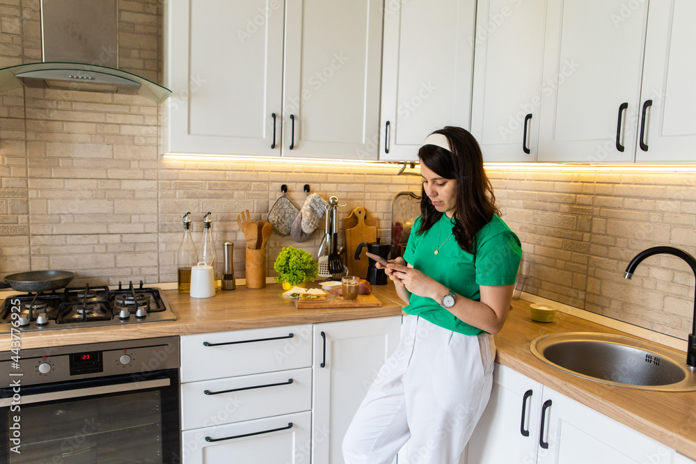 woman on the kitchen having breakfast sandwich with coffee woman on the kitchen having breakfast sandwich with coffee