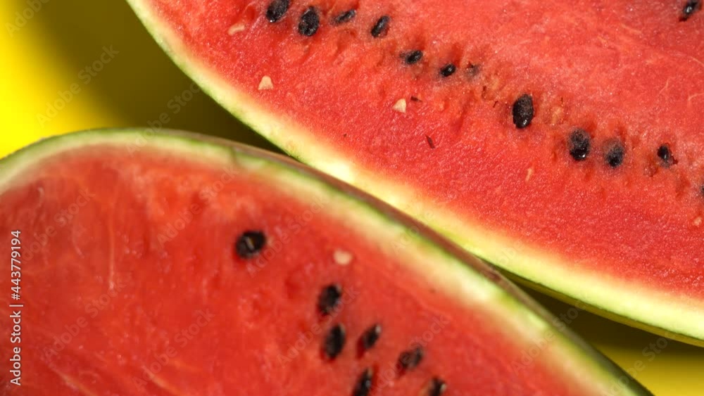Two slices of red watermelone on yellow backgroung Two slices of red watermelone on yellow backgroung