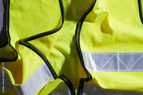 close up of yellow color safety vest with silver reflector photo