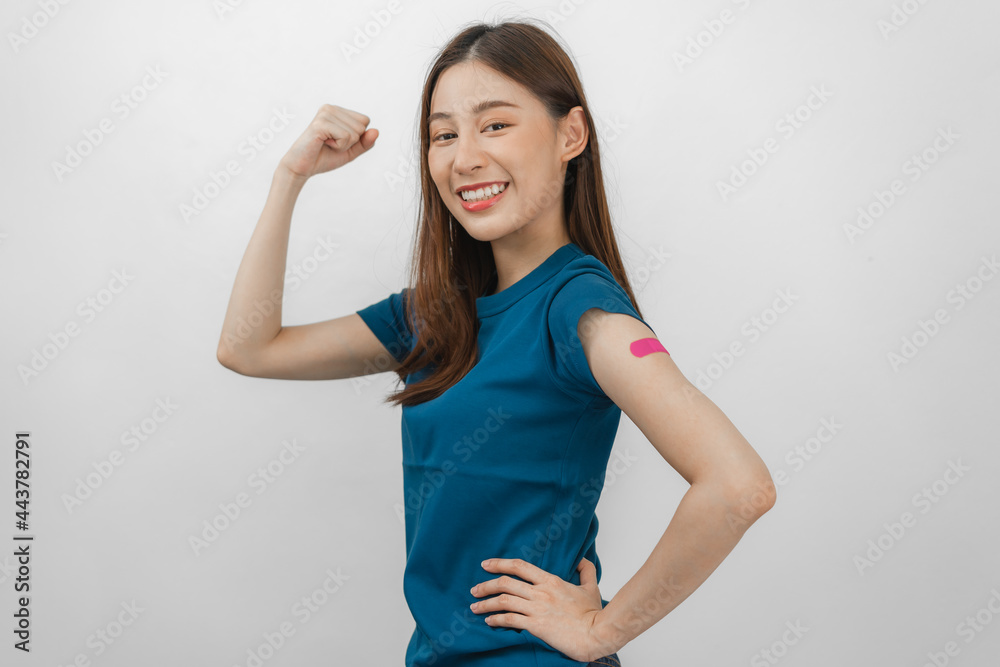 Portrait of pretty, beautiful asian young, teenage attractive after getting, receive anti virus vaccine covid-19. Showing arm on pink bandage in blue t-shirt isolated on white background, copy space Portrait of pretty, beautiful asian young, teenage attractive after getting, receive anti virus vaccine covid-19. Showing arm on pink bandage in blue t-shirt isolated on white background, copy space