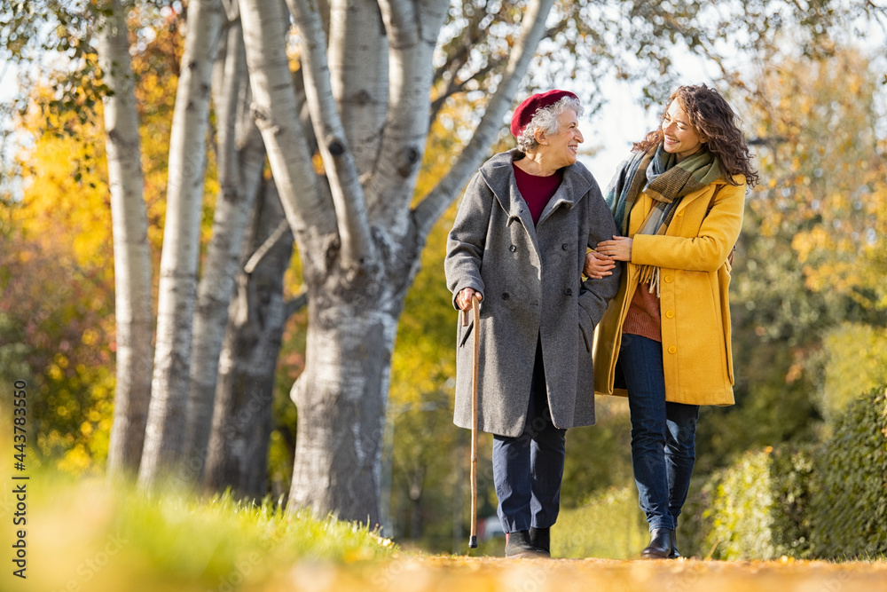 Woman with grandmother walking in park in autumn Woman with grandmother walking in park in autumn