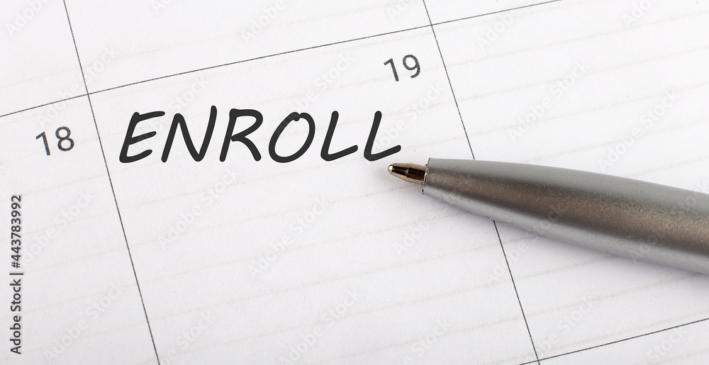 Text ENROLL on calendar planner to remind you an important appointment with a pen on isolated white background. Text ENROLL on calendar planner to remind you an important appointment with a pen on isolated white background.