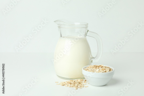 Pitcher of milk and cereals on white background