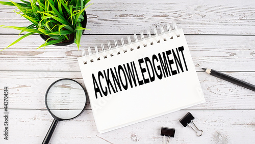 Photography ACKNOWLEDGMENT text concept write on notebook with office tools on wooden backgr