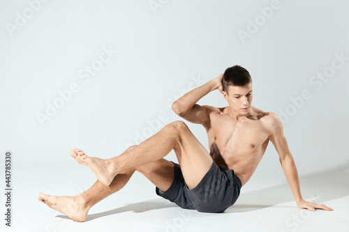 morning exercises young athlete in gray shorts and an inflated torso fitness workout