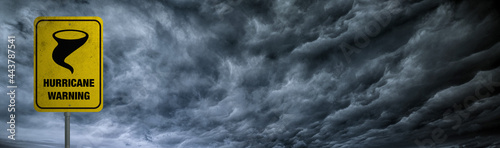 Hurricane warning banner with storm clouds background.