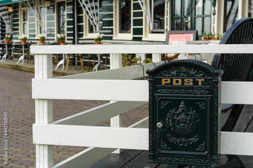 Black post box on the usual holland street. One usual post box in the Netherlands