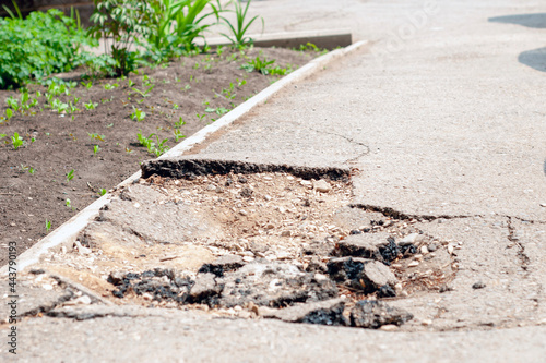 damaged broken asphalt, a hole on the sidewalk