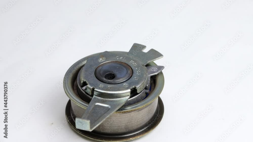 Defective used car timing belt tensioner on white background. Close-up, automotive Defective used car timing belt tensioner on white background. Close-up, automotive