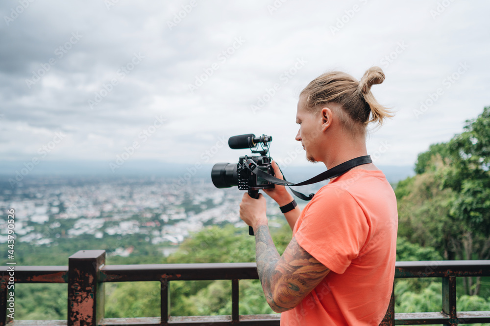 Man videographer shooting amazing landscape from high viewpoint