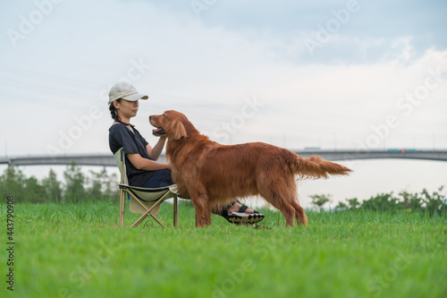 Tableau sur toile Golden Retriever accompanies its owner on the grass