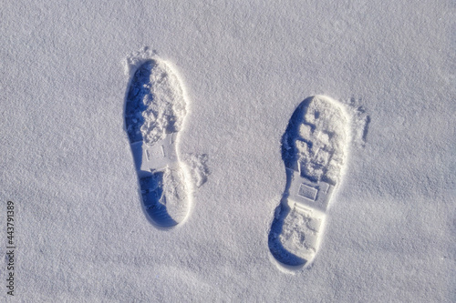 Two boot prints on the surface of the snow
