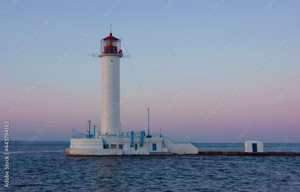 Odessa, Ukraine, 06.21.20. View of the lighthouse against the backdrop of the sunset.