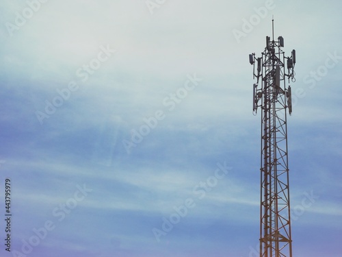 Telephone tower with white clouds in the background.