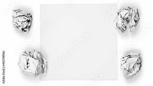 Paper being crumbled into white balls and a yellow light bulb on white background. Concept of Idea, Innovation and Creativity. High quality 4k video.