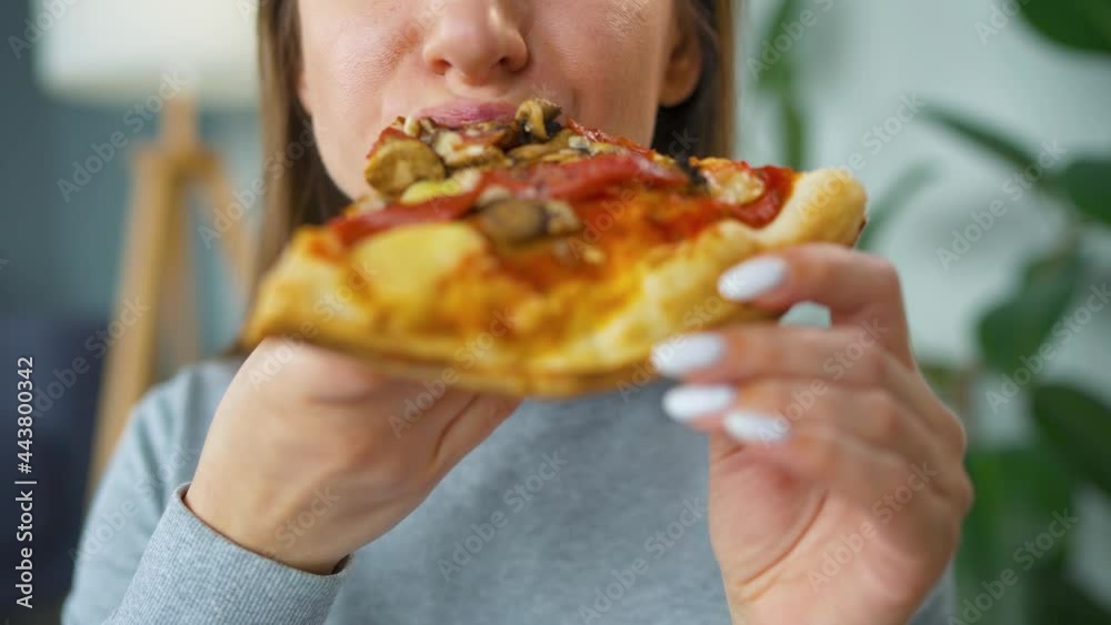 Woman eating pizza. Close-up. Concept of quick bites and unhealthy food Woman eating pizza. Close-up. Concept of quick bites and unhealthy food