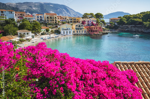 Assos on Cephalonia Kefalonia Ionian island in Greece. Vivid pink flower in foreground. Summer travel vacation