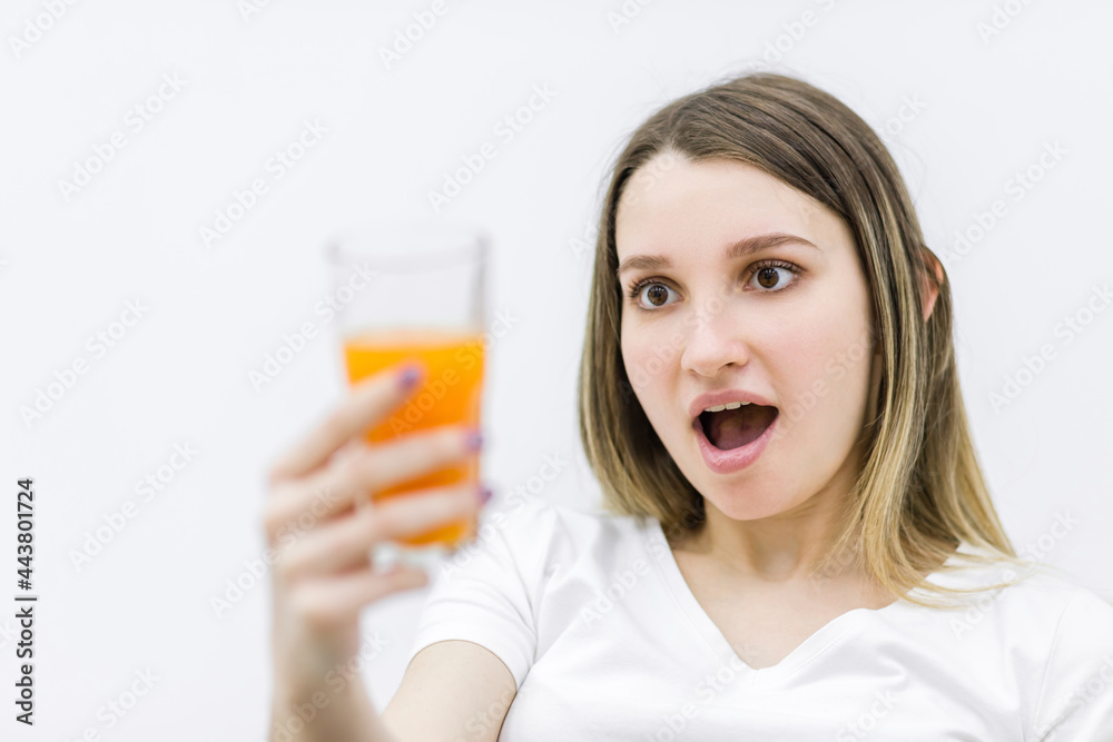 Photo of pregnant woman looking at the glass of orange juice. Photo of pregnant woman looking at the glass of orange juice.
