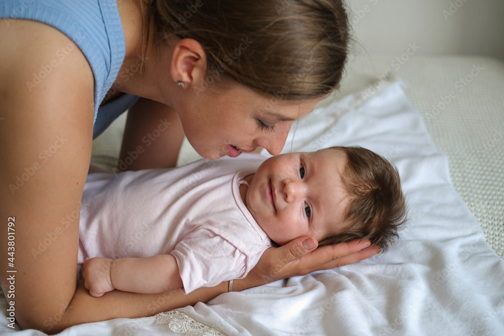 Attractive happy mother kiss lying with little baby girl. Happy family Attractive happy mother kiss lying with little baby girl. Happy family