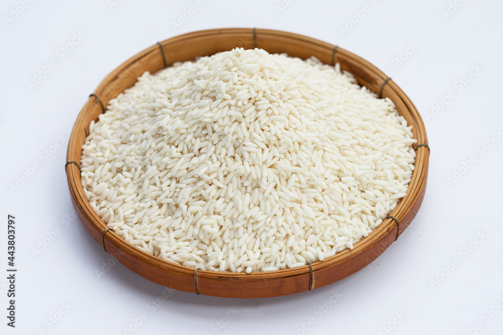 Raw sticky rice in bamboo basket on white background. Raw sticky rice in bamboo basket on white background.