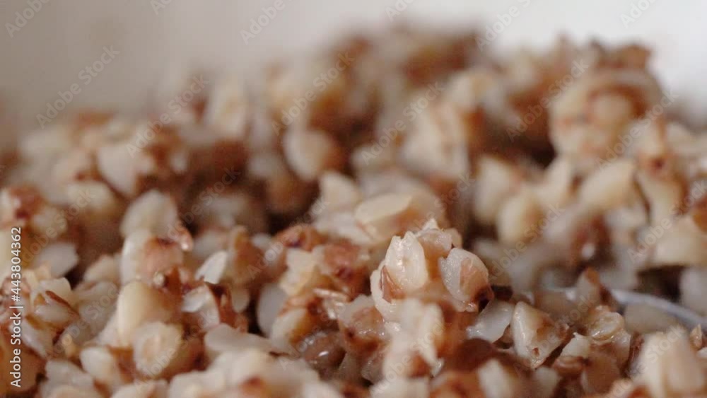 Cooked buckwheat porridge is stirred with a spoon. macro. Slow motion. High quality FullHD footage Cooked buckwheat porridge is stirred with a spoon. macro. Slow motion. High quality FullHD footage