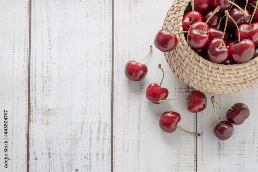 summer background with a basket of cherries on a wooden background, sweet ripe red berries are scattered on the table, rustic style, copy space summer background with a basket of cherries on a wooden background, sweet ripe red berries are scattered on the table, rustic style, copy space