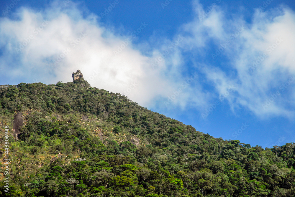 Pedra Peito do Pombo, famous rock formation on top of mountain surrounded by tropical forest, blue sky, Arraial do sana, Macae district, State of Rio de Janeiro, Brazil