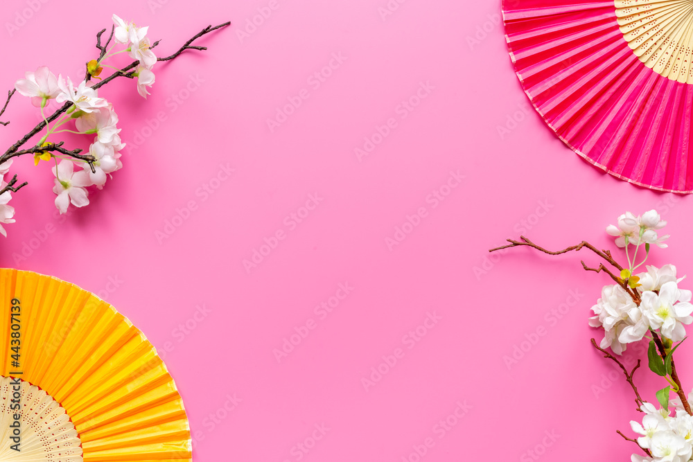 Japanese hand fan with cherry blossom branch. Top view