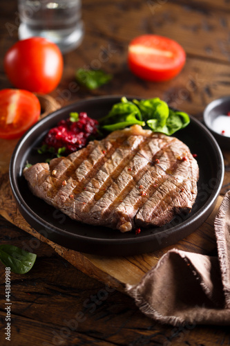 Grilled beef steak with fresh spinach