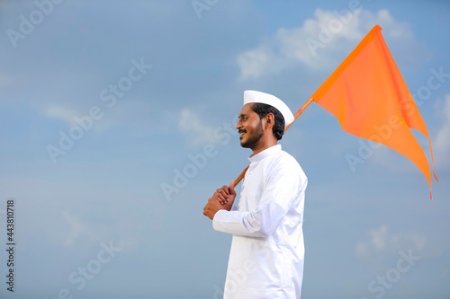 Young indian man (pilgrim) in traditional wear and waving religious flag. photo