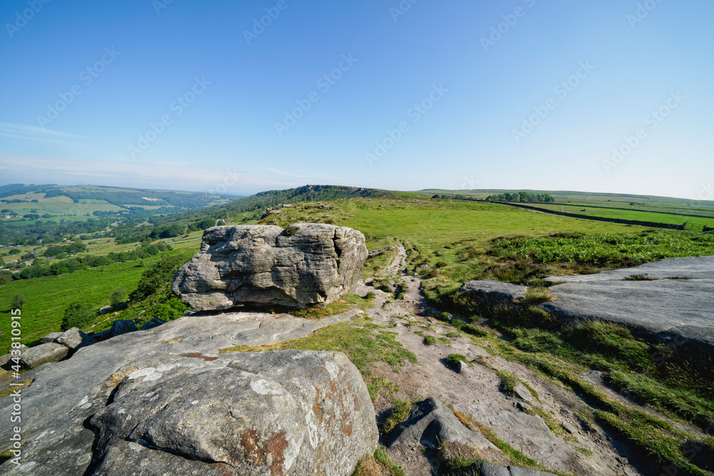 Narrow rutted path threads between large gritstone rocks on Baslow Edge