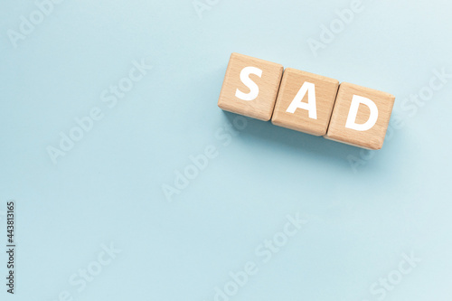 Text ETF on wooden cubes on blue background. Abbreviation of 'Seasonal affective disorder'. Square wood blocks. Top view, flat lay.  photo