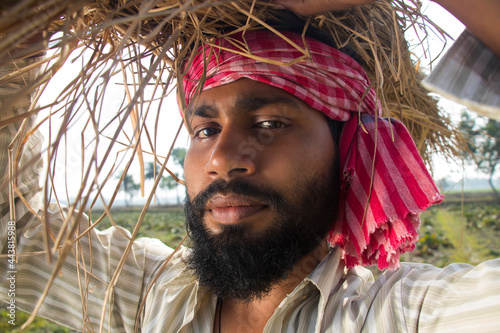 Indian Farmer Carrying Bundle of Paddy Crop photo