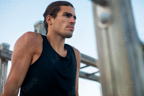 Sporty athletic man exercises at the beach. Handsome man training outdoors