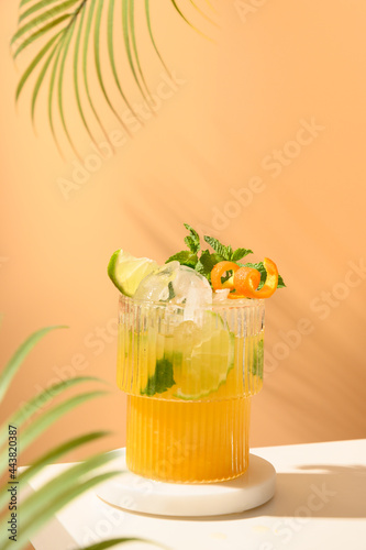 Classic freshness cocktail, mojito, lemonade or mai tai with lime, orange on modern still life on podium on beige background with shadow. Festive party. Summer holiday mocktail. photo