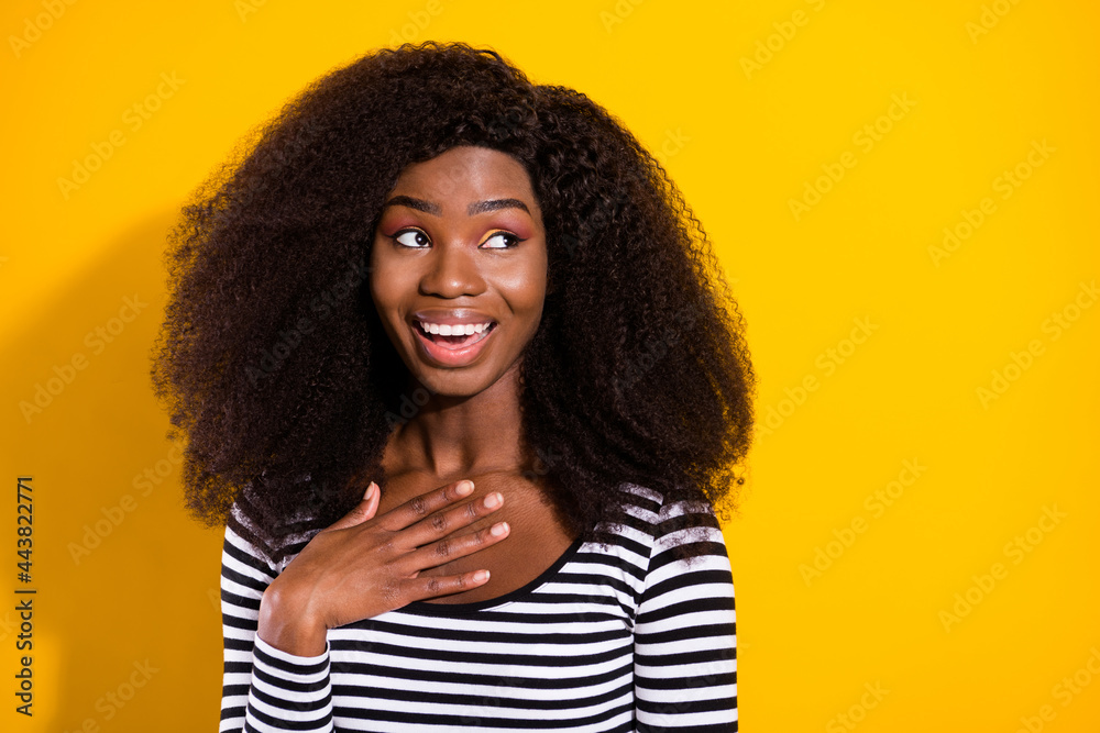 Photo portrait of young model smiling cheerfully looking copyspace hand on chest isolated bright yellow color background Photo portrait of young model smiling cheerfully looking copyspace hand on chest isolated bright yellow color background