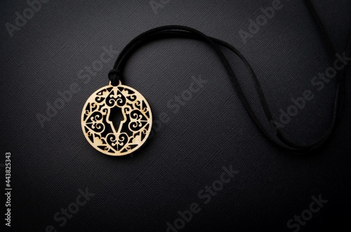 Yakut female amulet made of wood on a black background. Wooden traditional talisman. Boho style photo