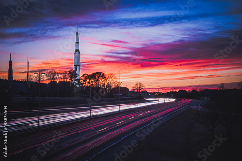 Space and Rocket Center with Long Exposure Light Trails from Cars with Sunset in the Background