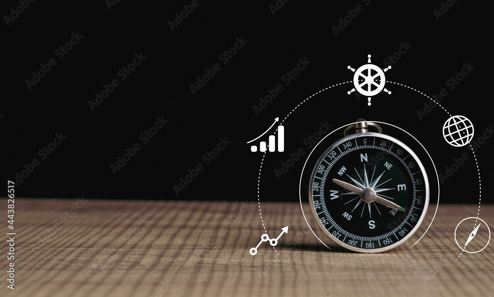 Business navigate concept, compass navigation on table for guide to recovery business planning growth in the economic crisis and trading graph financial data, action plan icon. - obrazy, fototapety, plakaty 
