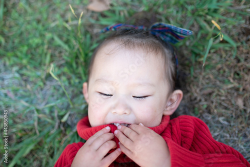 芝生で寝転ぶ笑顔の少女