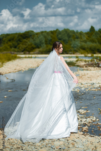 Fashion bride posing on mountain river. Wedding day
