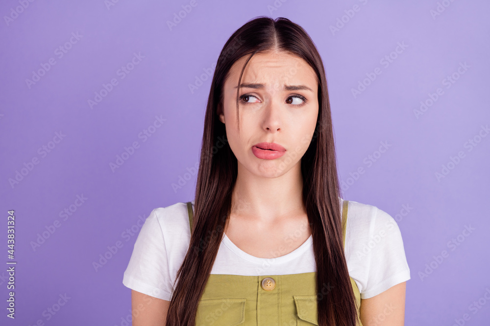 Photo of unhappy tired young woman dressed white t-shirt looking empty space isolated violet color background Photo of unhappy tired young woman dressed white t-shirt looking empty space isolated violet color background