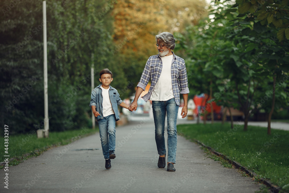 Grandfather with grandchild walking in a summer park