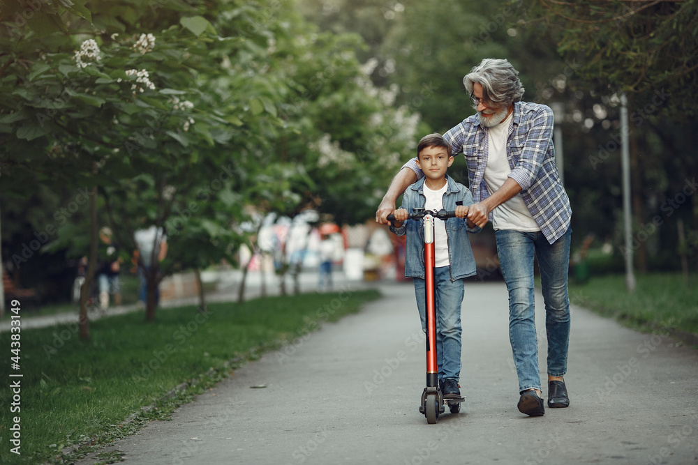 Grandfather with grandchild walking in a summer park