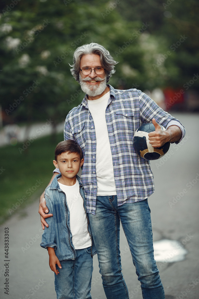 Grandfather with grandchild walking in a summer park Grandfather with grandchild walking in a summer park