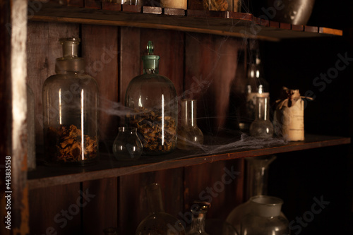 Halloween background Shelves with alchemy tools Skull spiderweb bottle with poison candles