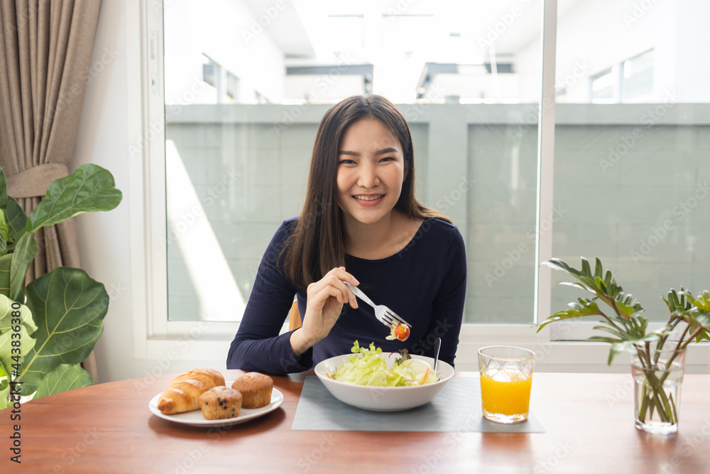Having meal concept a pretty woman mixing zero calories salad dressing with a green salad in the bowl Having meal concept a pretty woman mixing zero calories salad dressing with a green salad in the bowl